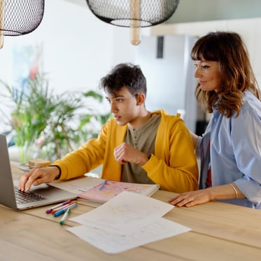 Mom and son building a budget looking at a laptop