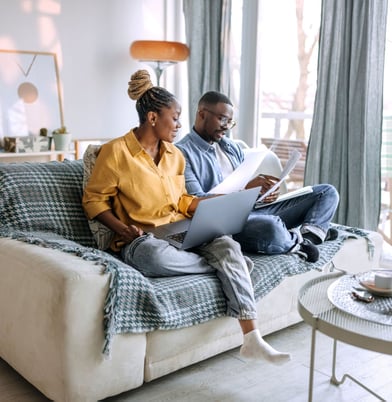 Couple on couch discussing finances