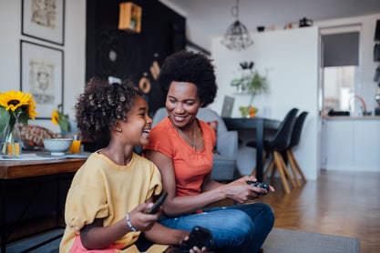 Mother & daughter having fun playing video games